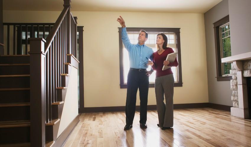 Two people standing in front of a house with stairs.