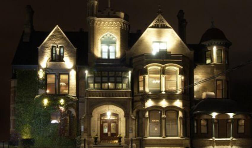 A large mansion lit up at night.