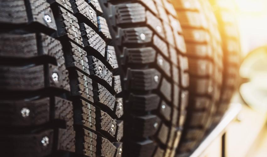 A row of tires on a shelf in front of the sun.