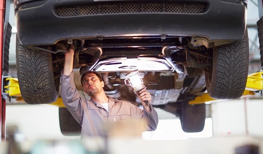 A mechanic working on a car in a garage.