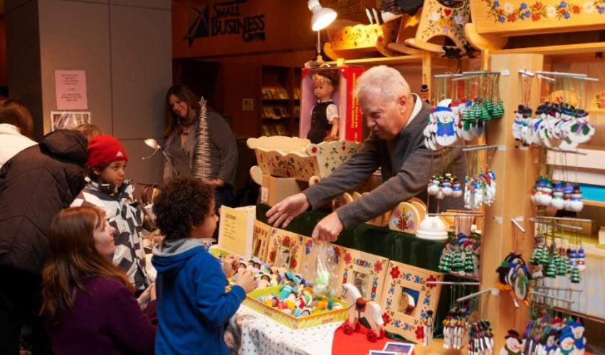 A group of people looking at a display of ornaments.