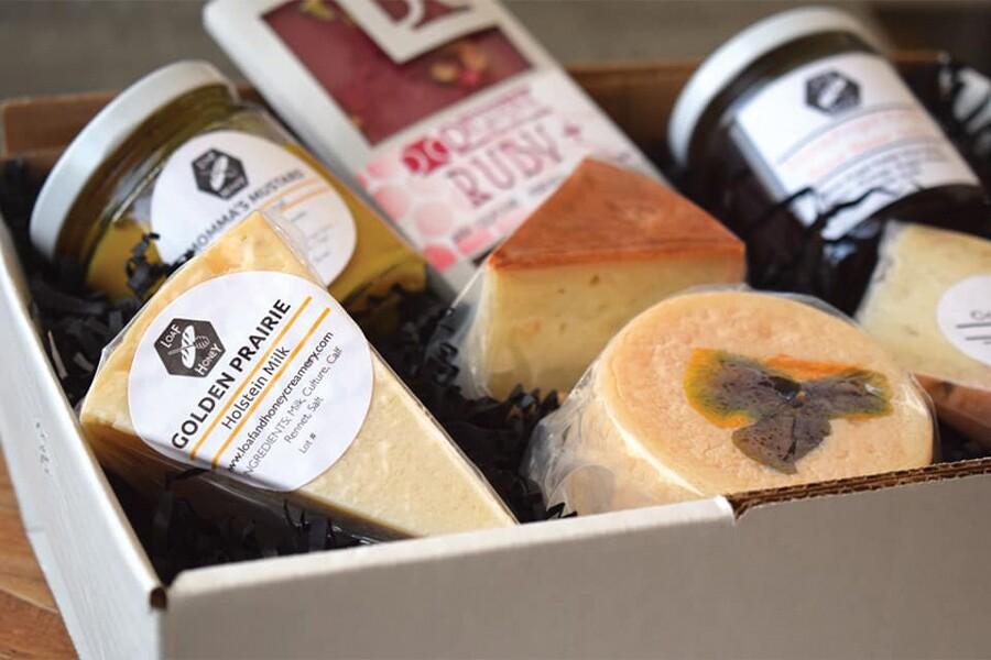 A box filled with cheese and other foods.