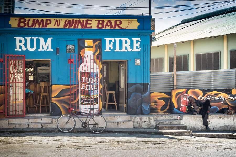 A bicycle is parked in front of a rum bar.