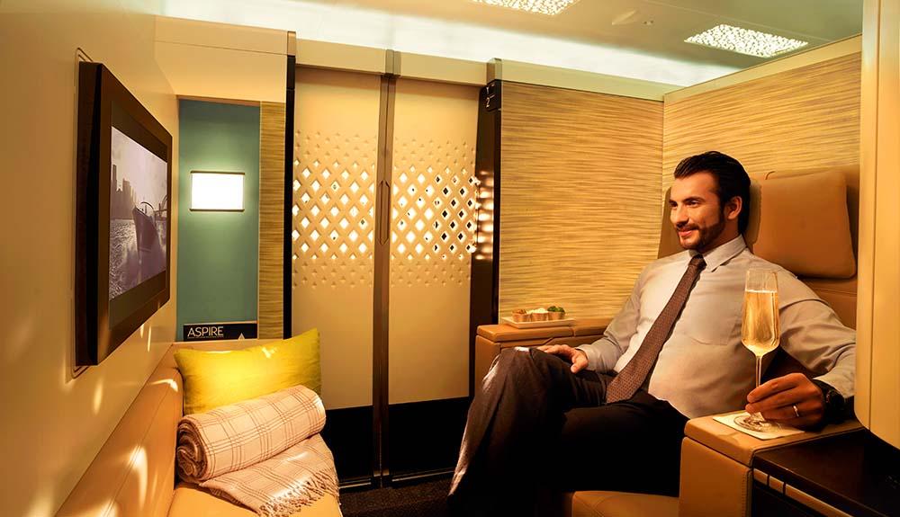 A man in a suit sitting in an airplane cabin.