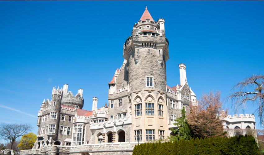 An ornate castle sits on top of a hill.