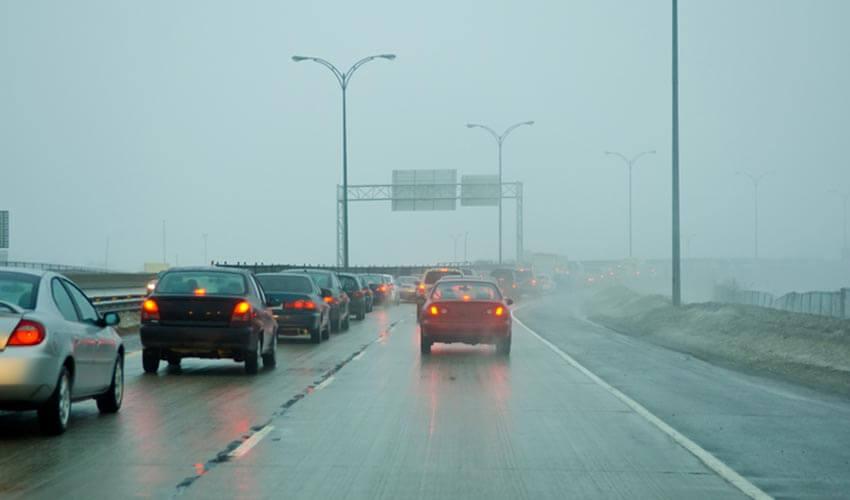Traffic on a highway in a foggy day.