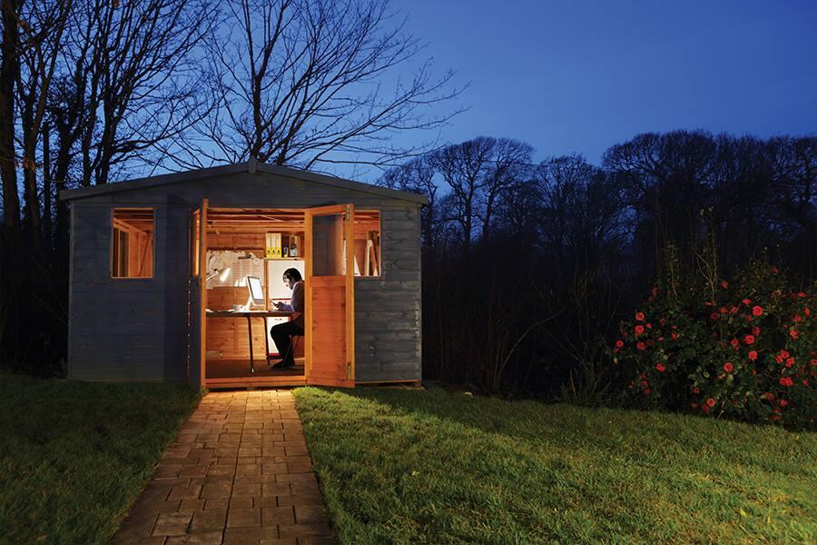 A person sitting in a shed at night.