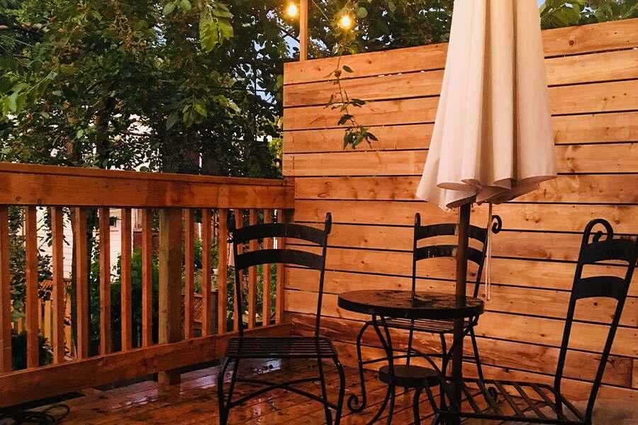 A wooden deck with a table and chairs.