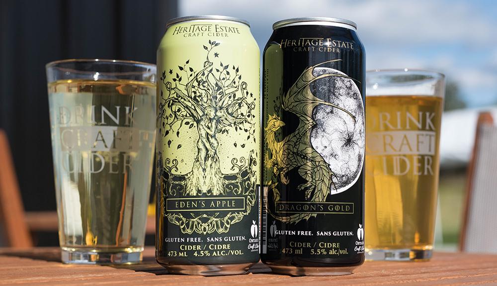 Three cans of beer sitting on a wooden table.