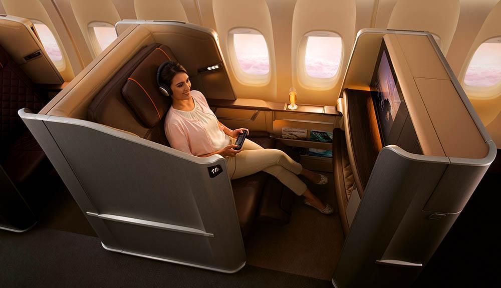 A woman is sitting in a seat on an airplane.