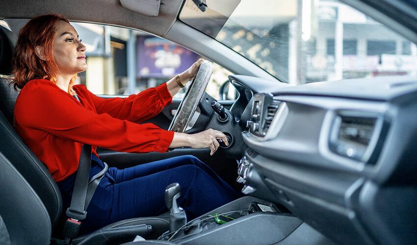 A woman sitting in the driver's seat of a car.