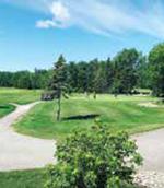 A well-manicured golf course with clear skies.