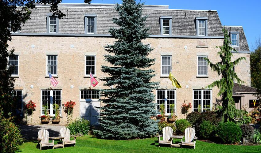 A large stone building with lawn chairs in front of it.