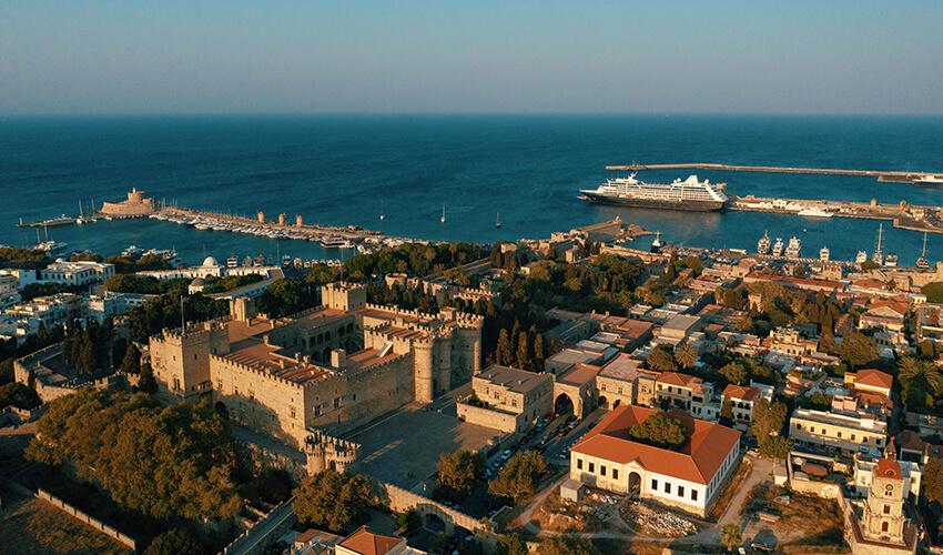 An aerial view of a city with a cruise ship docked.
