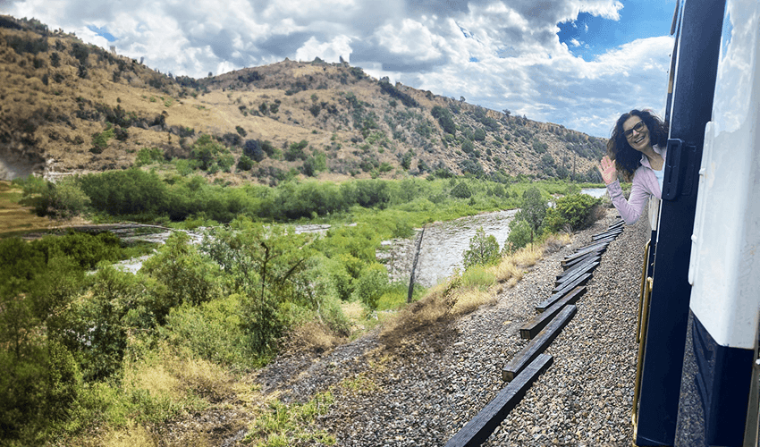 A woman is looking out the window of a train.