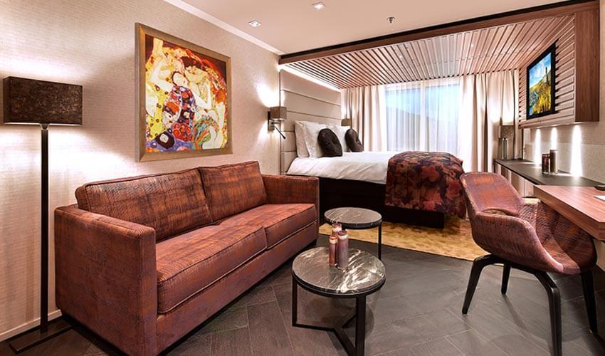 A room with a bed, couch and tv.