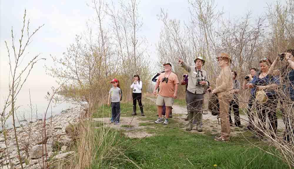 A group of people standing near a body of water.