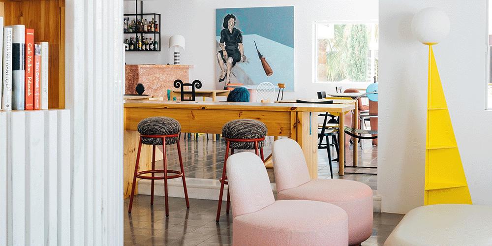 A room with stools and a painting on the wall.
