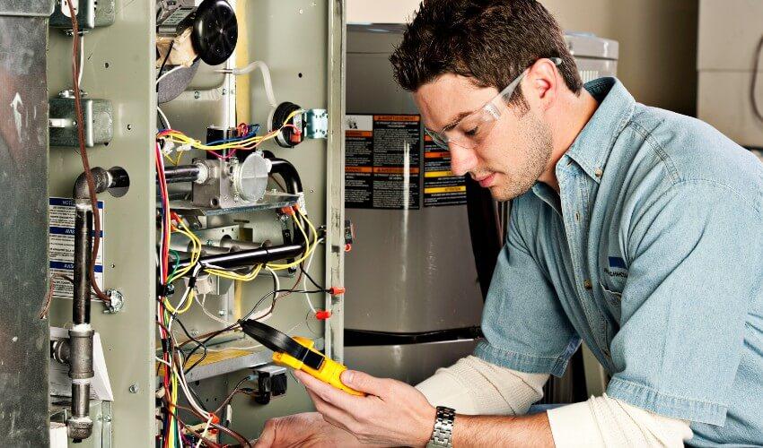 A man is working on a furnace.