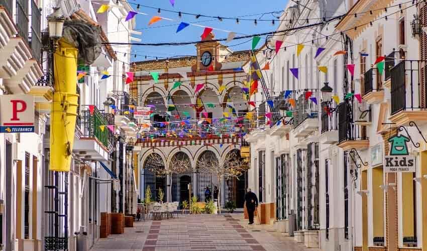 A narrow street lined with colorful flags and banners.