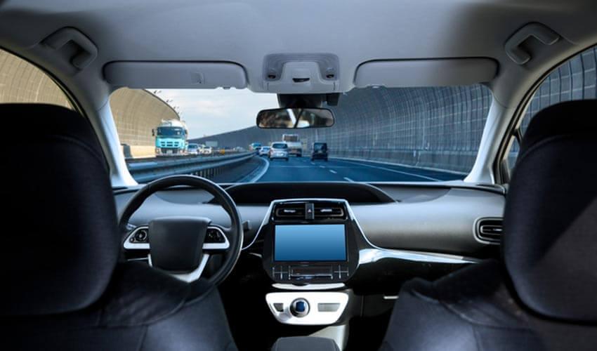 The interior of a car with a view of a highway.