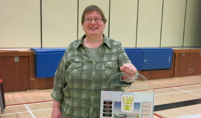 A woman holding up a sign in a gym.