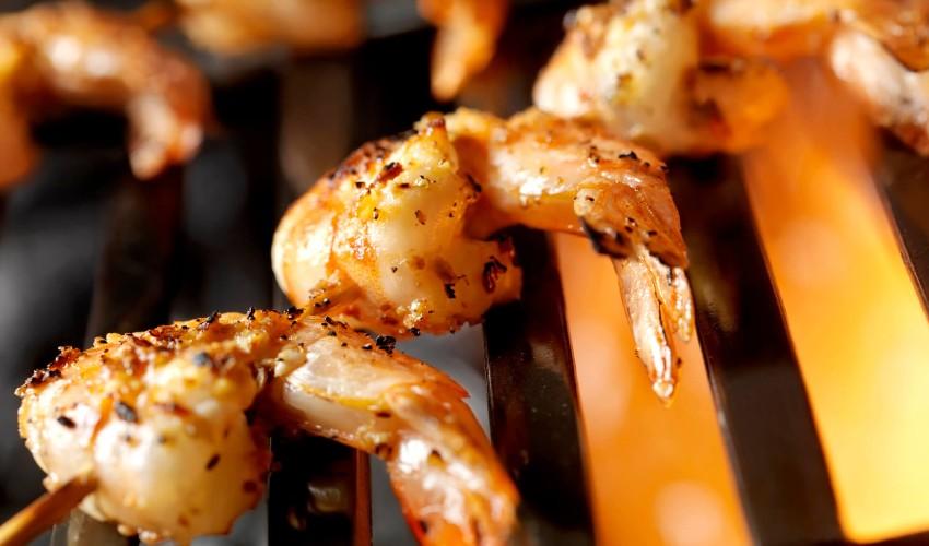Grilled shrimp on skewers on a grill.