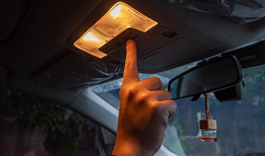 A person is pointing at something in a car.