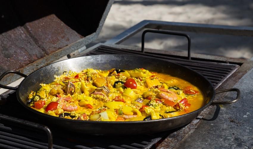A pan full of food cooking on a grill.