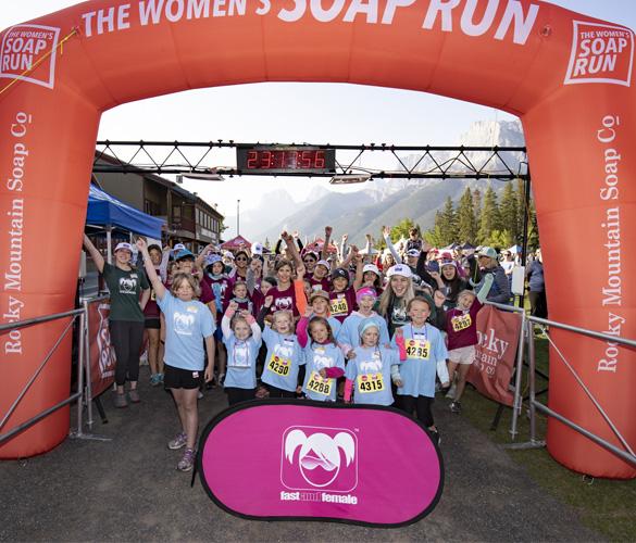 A group of participants celebrating at the finish line of the women's soap run event.