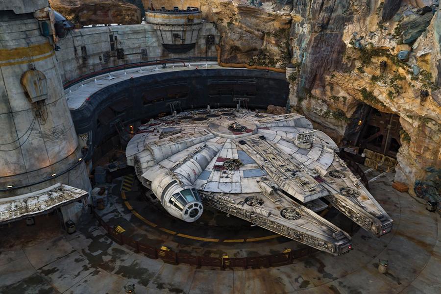 A star wars millennium falcon sits inside a cave.