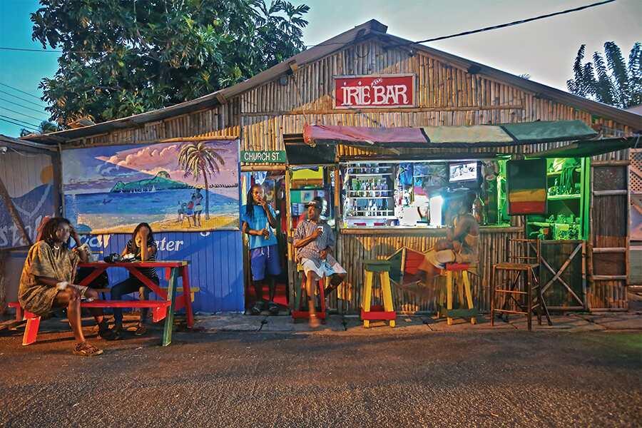 A group of people sitting outside of a bar.