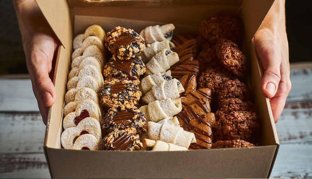 A person holding a box of cookies.