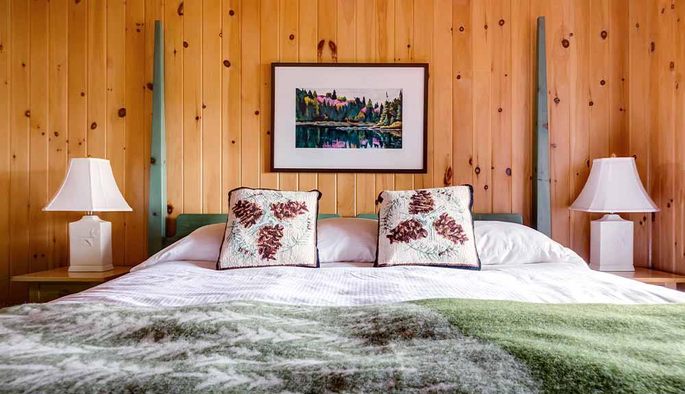 A bed in a bedroom with wood paneling.