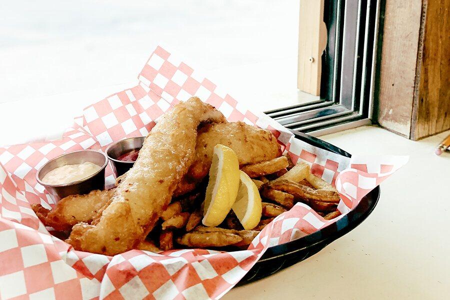 A basket of fried fish and fries.