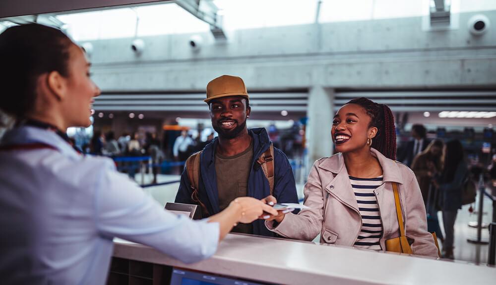 A group of people standing at the counter at an airport.