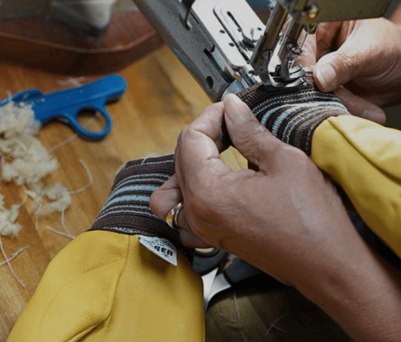 Person sewing a striped fabric using a sewing machine.
