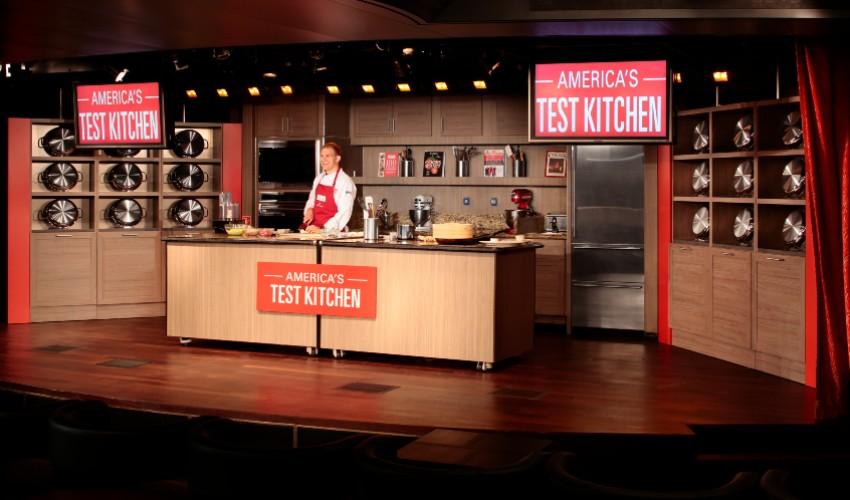 A man is standing in front of a kitchen.