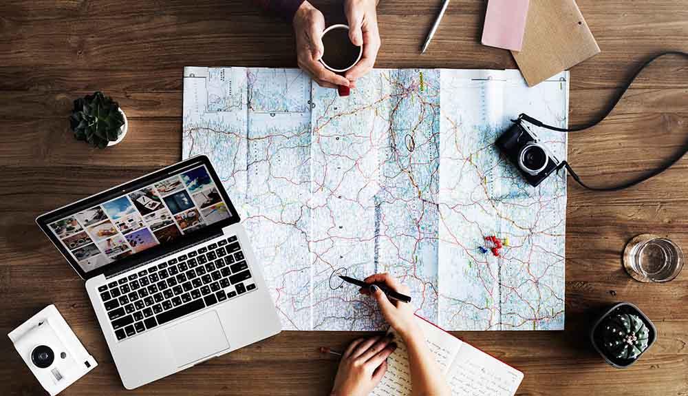 A group of people sitting at a table with a map and a laptop.