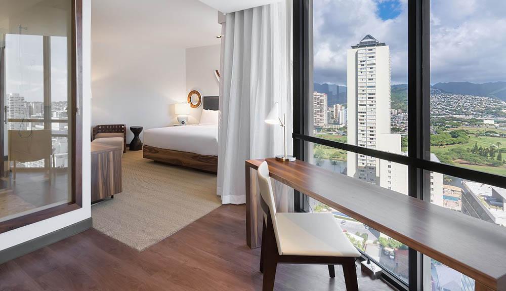 A hotel room with a view of a city.