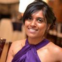 A woman in a purple dress smiling for the camera.