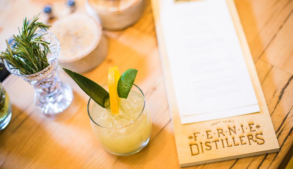 A drink is sitting on a wooden table next to a menu.