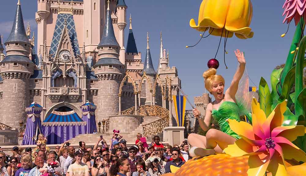 A tinker bell float in front of a castle.