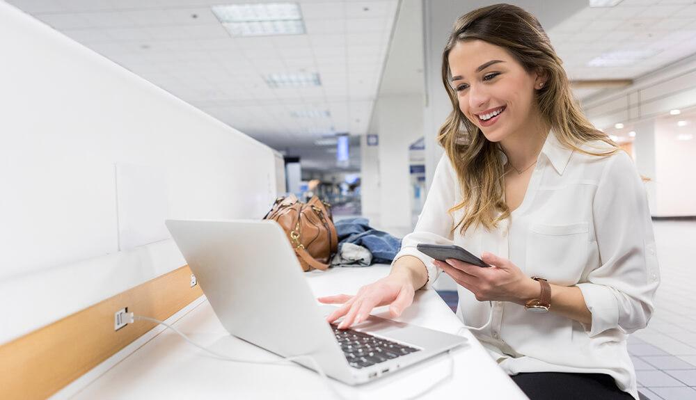 A woman using a laptop in an airport.