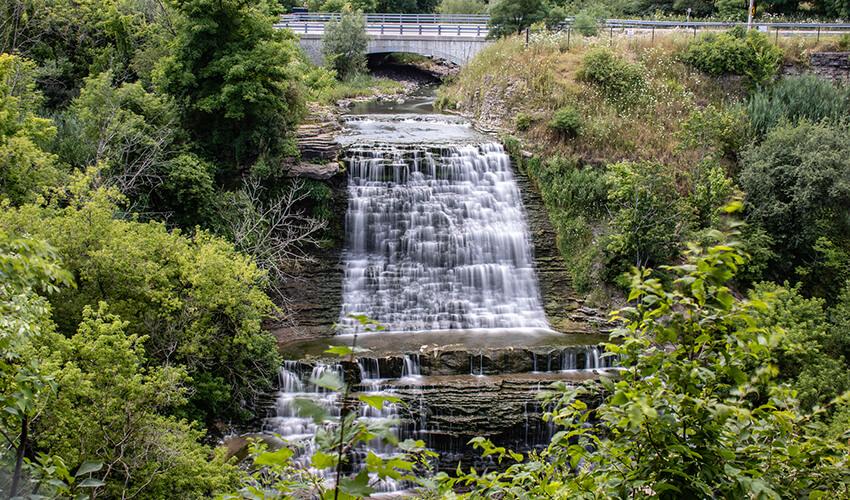 A waterfall in the middle of a wooded area.