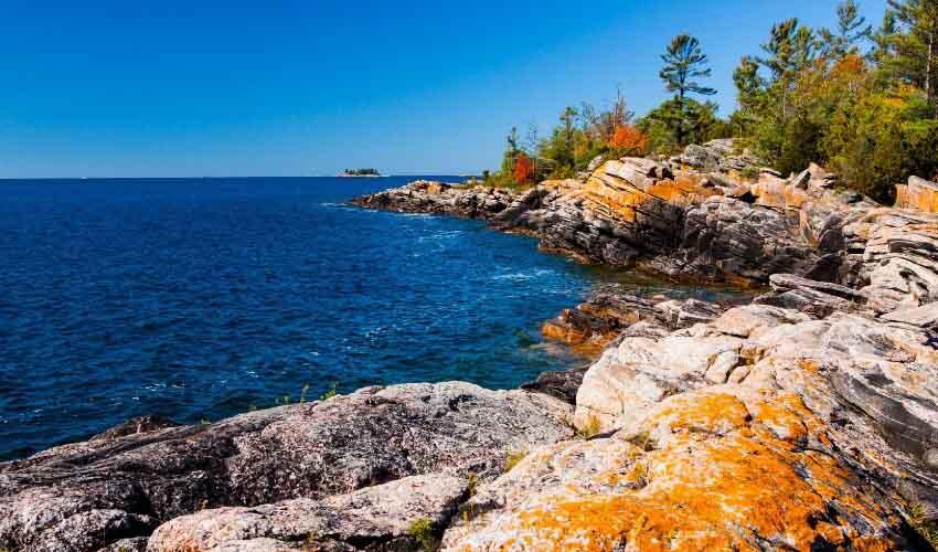 A rocky shoreline with a blue sky and a rocky shoreline.