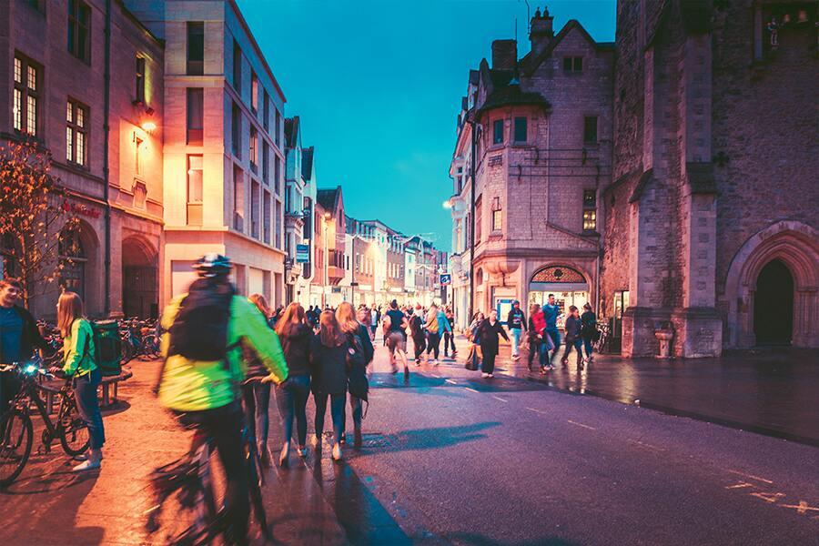 A group of people riding bikes on a city street at night.