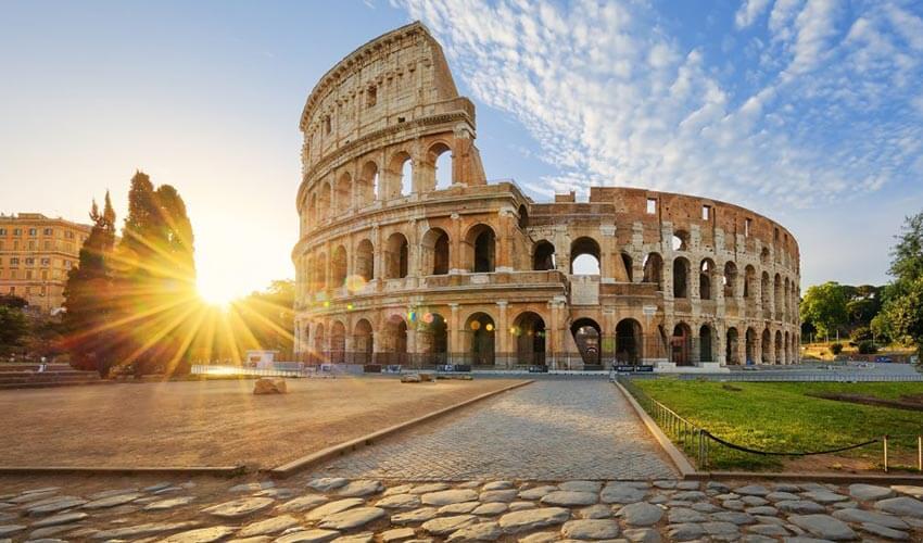 A stone building with a circular structure with leaning tower of pisa in the background.