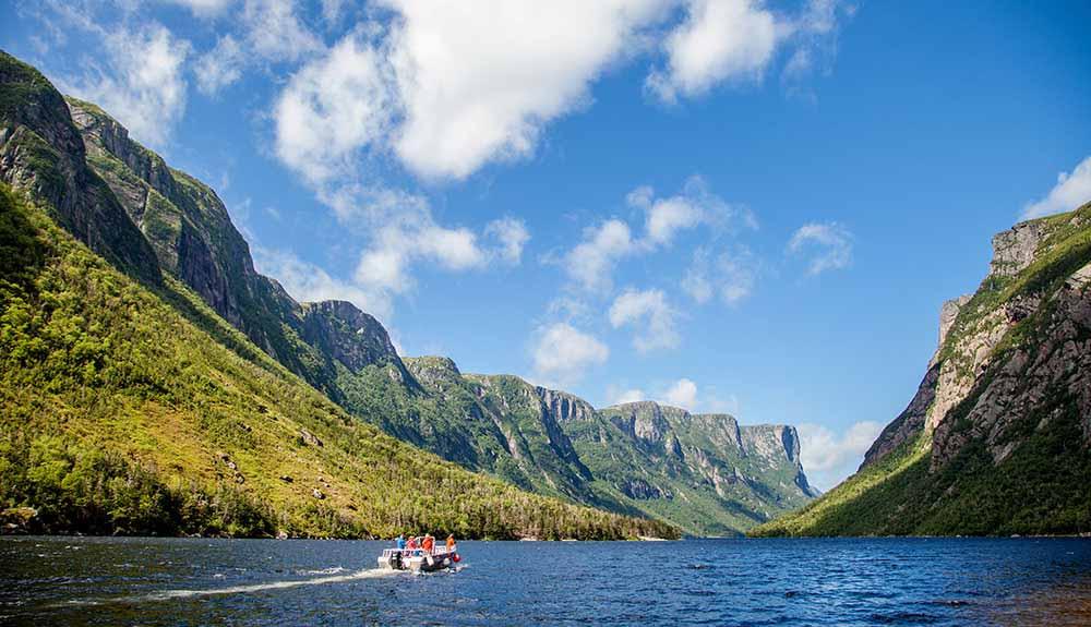 A boat on a lake with mountains in the background.