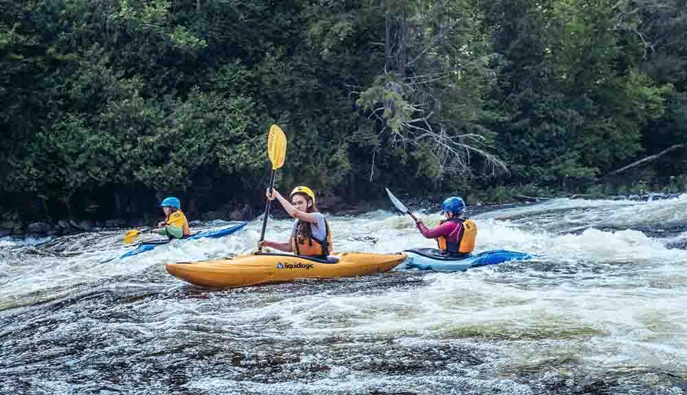 A group of people in kayaks on a river.